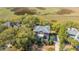 Aerial view showcases the brick home surrounded by mature trees and overlooking serene marshland at 1521 Hurtes Island Dr, Charleston, SC 29407