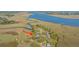 Expansive aerial view captures a waterfront home surrounded by marshland and a distant bridge, highlighting its tranquil setting at 1521 Hurtes Island Dr, Charleston, SC 29407
