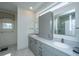 Bright bathroom with a double vanity, gray cabinets, tile floors, and modern fixtures at 1521 Hurtes Island Dr, Charleston, SC 29407