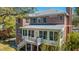 Brick home featuring a screened porch and back staircase to the yard with mature trees around at 1521 Hurtes Island Dr, Charleston, SC 29407