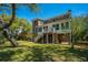 Brick home exterior with screened porch, back staircase, and lush landscaping including mature trees at 1521 Hurtes Island Dr, Charleston, SC 29407