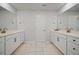 Well-lit bathroom featuring double sinks with white countertops, modern fixtures, and tiled flooring at 158 Woodland Oak Way, Summerville, SC 29485