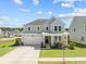 Charming two-story home features a well-manicured lawn, attached two-car garage, and welcoming front porch at 158 Woodland Oak Way, Summerville, SC 29485