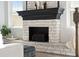 Close up shot of the brick fireplace with a black mantel and hearth, adding character and charm to the living space at 158 Woodland Oak Way, Summerville, SC 29485