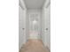 Hallway with neutral carpet and bright white paint leading to the white tiled bathroom at 158 Woodland Oak Way, Summerville, SC 29485