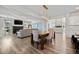 Open-concept living and dining space with hardwood floors, modern lighting, and a cozy fireplace at 158 Woodland Oak Way, Summerville, SC 29485