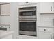 Built-in stainless steel oven and microwave appliances with white cabinetry and backsplash at 158 Woodland Oak Way, Summerville, SC 29485