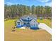 An impressive white farmhouse with lush green lawn, and a backdrop of tall trees on a sunny day at 161 Ryefield Ln, Ridgeville, SC 29472