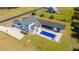 Elevated perspective of a backyard oasis showcasing a pristine pool, a cozy lounge area, and well-groomed lawn at 161 Ryefield Ln, Ridgeville, SC 29472