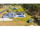 Stunning aerial view of modern farmhouse with an in-ground pool, outdoor living space, and a three car garage on a spacious lot at 161 Ryefield Ln, Ridgeville, SC 29472