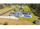 Gorgeous aerial view of a white farmhouse with an in-ground pool, an outdoor living space, and a long driveway on a large lot at 161 Ryefield Ln, Ridgeville, SC 29472