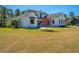 Charming white two-story home with lush green lawn, mature trees, and professional landscaping at 161 Ryefield Ln, Ridgeville, SC 29472