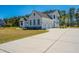Expansive white two-story home boasting an attached three-car garage and a sprawling driveway at 161 Ryefield Ln, Ridgeville, SC 29472