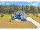 Beautiful front exterior of modern farmhouse with a long driveway and well manicured lawn at 161 Ryefield Ln, Ridgeville, SC 29472
