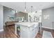 Modern kitchen with a central island, marble countertops, and a view of the living area at 161 Ryefield Ln, Ridgeville, SC 29472
