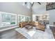 Spacious living room with hardwood floors, large windows and comfortable leather furniture at 161 Ryefield Ln, Ridgeville, SC 29472