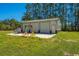 Outbuilding featuring a three-door garage and work equipment at 161 Ryefield Ln, Ridgeville, SC 29472