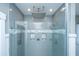 Modern walk-in shower with gray tiling, rainfall showerhead, and glass enclosure at 161 Ryefield Ln, Ridgeville, SC 29472