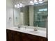 Bathroom features a double sink vanity with granite countertop, large mirror, and shower at 1659 Seabago Dr, Charleston, SC 29414