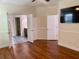 Spacious main bedroom with ceiling fan, tv, hardwood floors, and ensuite bathroom entry at 1659 Seabago Dr, Charleston, SC 29414