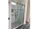 Modern bathroom shower with sliding glass door, white subway tile, and a built-in niche at 1659 Seabago Dr, Charleston, SC 29414