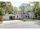 Exterior view of home with covered parking, well-manicured lawn, and mature trees at 1706 W Avalon Cir, Charleston, SC 29407