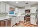 Well-lit kitchen featuring white cabinets, stainless steel appliances, and a window with a neutral-toned shade at 1706 W Avalon Cir, Charleston, SC 29407