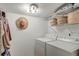 Functional laundry room with a washer, dryer, and shelving for storage, ideal for convenient laundry tasks at 1706 W Avalon Cir, Charleston, SC 29407