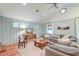 Cozy living room features wood paneled walls, a ceiling fan, and ample natural light at 1706 W Avalon Cir, Charleston, SC 29407