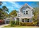 Charming two-story home featuring a gray exterior, well-manicured lawn, and lush landscaping with mature trees at 1810 Fleming Woods Rd, Charleston, SC 29412