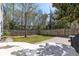 Spacious backyard with a wooden fence, a stone patio, a small grassy area, and various trees at 1826 Towne St, Johns Island, SC 29455