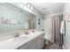 Charming bathroom featuring a double vanity, large mirror, and shower with colorful striped curtain at 1826 Towne St, Johns Island, SC 29455