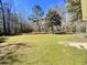 Large grassy backyard with mature trees and expansive space, creating an ideal area for outdoor enjoyment at 1848 Merrick Dr, Round O, SC 29474