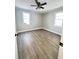Bright bedroom with wood-look floors, ceiling fan, and abundant natural light from two windows at 1848 Merrick Dr, Round O, SC 29474