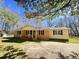 Charming single-story home with brick facade, covered porch, and mature trees in a large yard at 1848 Merrick Dr, Round O, SC 29474