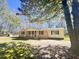 Charming single-story home with brick facade, covered porch, and mature trees in a large yard at 1848 Merrick Dr, Round O, SC 29474