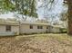 Back exterior view of a charming home with mature shade trees and a well-maintained yard at 1876 Chilhowee Dr, Johns Island, SC 29455