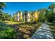 Beautiful yellow apartment building with a manicured lawn and a sidewalk leading to the entrance at 1928 Chatelain Way, Mount Pleasant, SC 29464