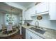Galley-style kitchen features white cabinets, stainless steel appliances, and granite countertops at 1928 Chatelain Way, Mount Pleasant, SC 29464