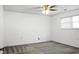 A brightly lit, unfurnished bedroom with gray carpet, a ceiling fan, and window at 201 Miami St, Ladson, SC 29456