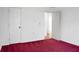 Bedroom with red carpet, white walls, and a door opening to an adjacent room at 201 Miami St, Ladson, SC 29456