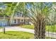 View of well-kept single-story home framed by a tall palm tree and showcasing the neutral siding and tidy landscaping at 201 Miami St, Ladson, SC 29456