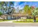 Charming single-story home with a circular driveway, mature trees, and verdant lawn on a bright sunny day at 201 Miami St, Ladson, SC 29456