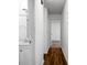 Hallway featuring wood floors leading to a bathroom and decorated with white walls and minimalist decor at 201 Miami St, Ladson, SC 29456