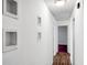 Hallway featuring wood floors leading to another room with a magenta carpet and decorated with artwork at 201 Miami St, Ladson, SC 29456