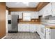 Charming kitchen with white cabinets, stainless steel appliances, butcher block counters and decorative tile flooring at 201 Miami St, Ladson, SC 29456