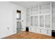 Open-concept living space with shuttered doors leading to the kitchen and featuring built-in shelving and display cabinets at 201 Miami St, Ladson, SC 29456