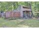 Rustic backyard outbuilding with wood siding and charming details surrounded by lush greenery at 208 Owens Dr, Summerville, SC 29485