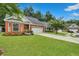 Lovely home with a brick facade, mature trees, and an ample driveway leading to a two-car garage at 215 Angora Way, Summerville, SC 29485