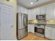 Galley kitchen showcasing stainless steel refrigerator, gas range, microwave and white cabinets at 215 Angora Way, Summerville, SC 29485